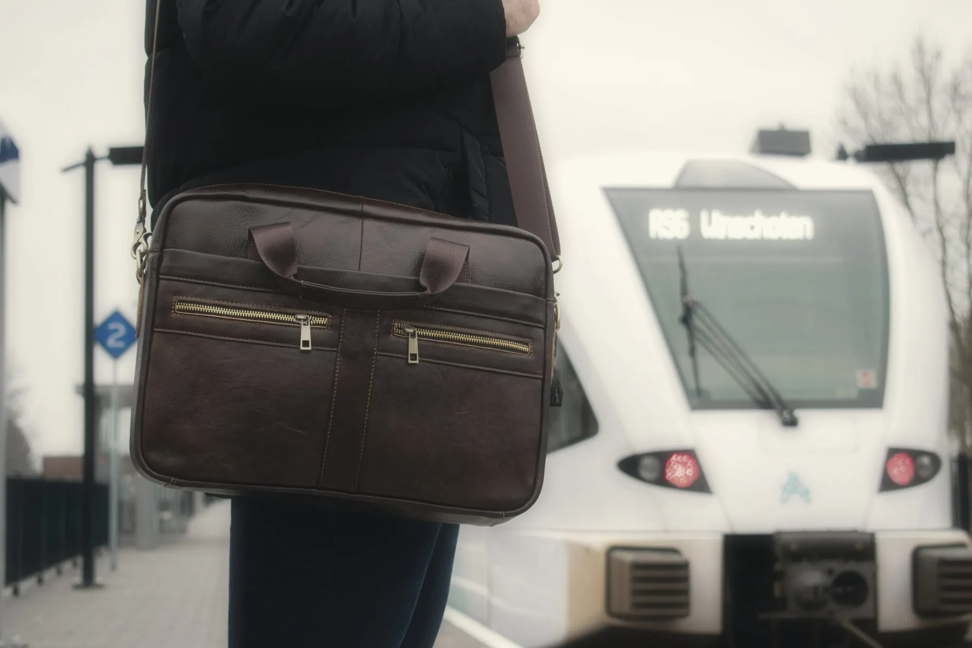 A briefcase on a Dutch train platform as a train pulls in