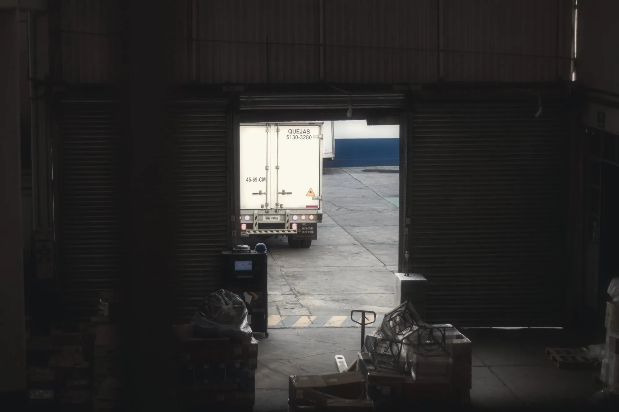 A truck backed up to a warehouse loading dock